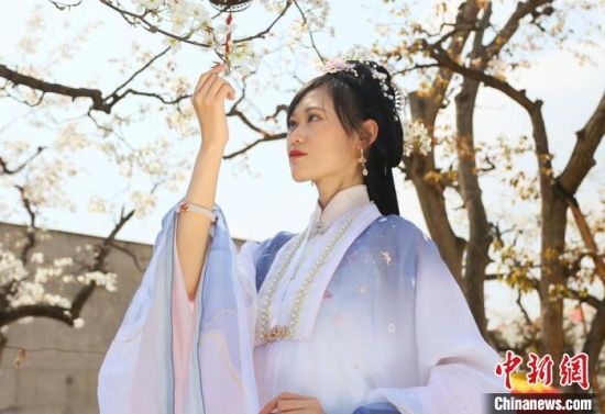 圖為蘭州青年身穿漢服在百年梨園賞景?！「哒?攝