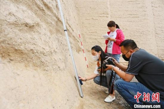 科技保護讓長城價值的真實性和完整性得到有效延續(xù)和傳承。圖為文物工作者正在測量關城的相關數(shù)據(jù)?！「哒?攝
