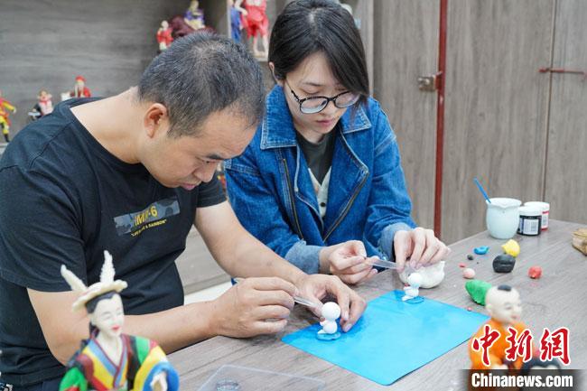 <a target='_blank'  data-cke-saved- >中新社</a>記者(右)現(xiàn)場體驗面塑制作過程。　陳爭強(qiáng) 攝