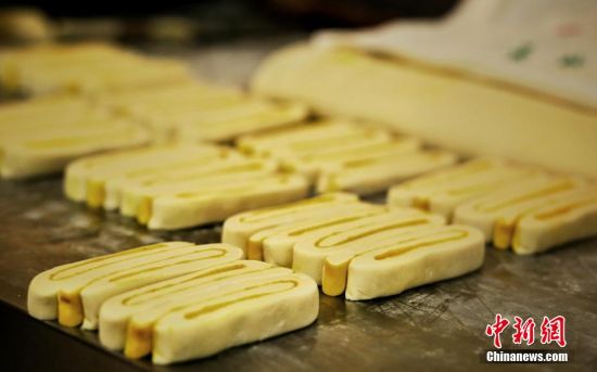 圖為面劑被涂上胡麻油，切成條狀用作月餅的花型制作。張文 攝