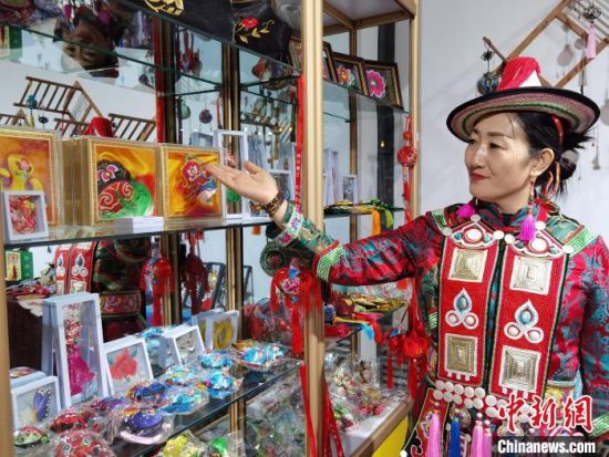 圖為身著民族服飾的隴原巧手展示手工藝品。(資料圖) 徐雪 攝