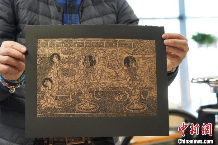 圖為手工書藝人展示敦煌雕版壁畫印刷品?！【琶赖┰?　攝