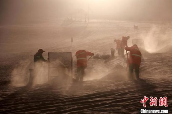 圖為敦煌市鳴沙山月牙泉景區(qū)“駱駝保姆”清理駱駝糞便。　張曉亮 攝