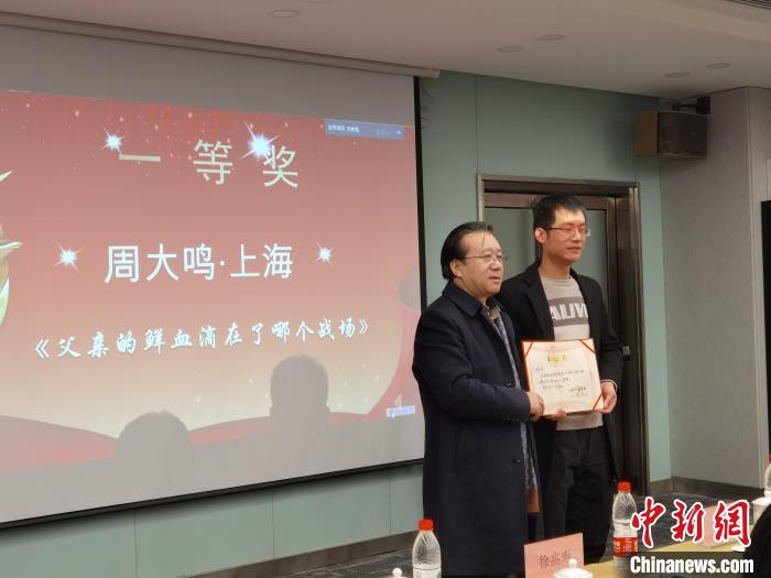 圖為作家、西北師范大學(xué)新聞與傳媒學(xué)院院長徐兆壽頒發(fā)一等獎證書，代領(lǐng)獎?wù)呱吓_領(lǐng)獎?！钅?攝