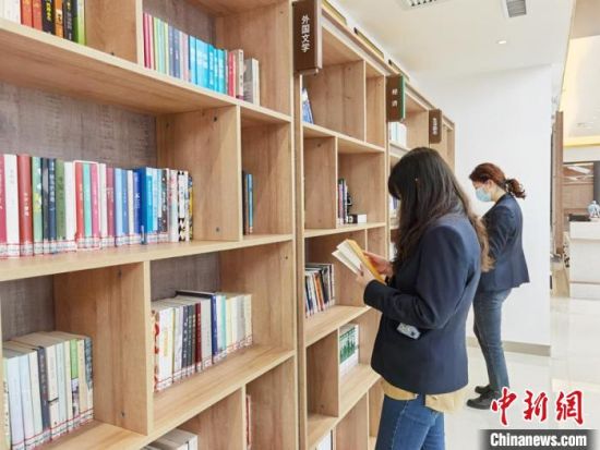 圖為在甘肅公航旅建設(shè)集團(tuán)有限公司的職工書屋，職工挑選書籍?！⌒煅?攝
