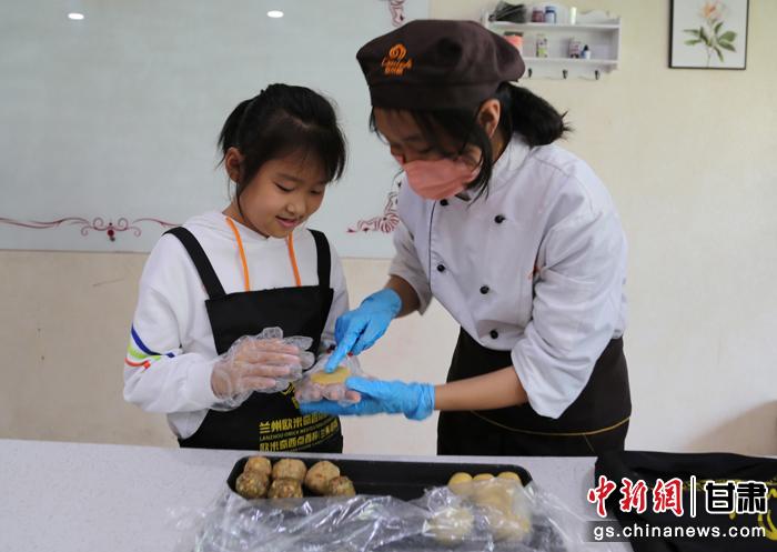 圖為在甘臺胞小朋友在工作人員指導(dǎo)下制作月餅。九美旦增 攝