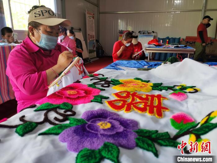 圖為婦女制作青繡?！?zhí)砀?攝