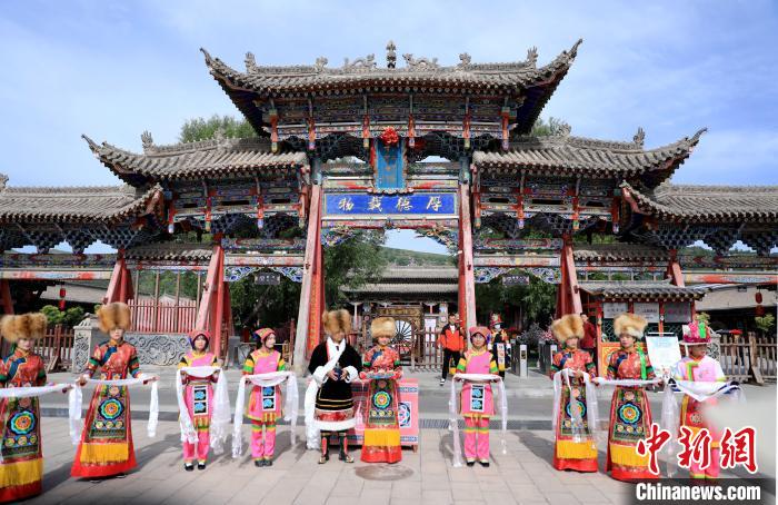 圖為身穿土族服飾的工作人員迎接訪客?！⊙Φ?攝