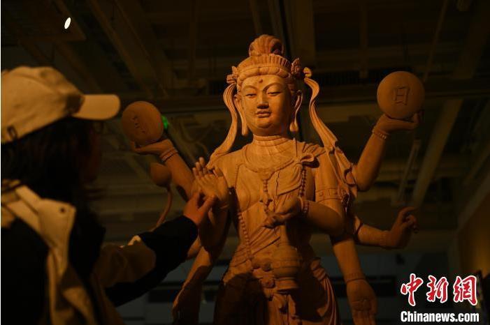 圖為季茂杰觀察自己創(chuàng)作的敦煌木雕。李亞龍 攝</p>
<p>