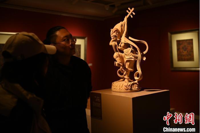 圖為季茂杰向參觀者介紹自己創(chuàng)作敦煌木雕的過(guò)程。李亞龍 攝</p>
<p>