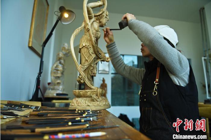 圖為季茂杰進(jìn)行敦煌元素的木雕創(chuàng)作。李亞龍 攝</p>
<p>