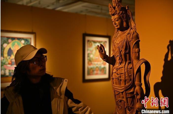 圖為季茂杰觀察自己創(chuàng)作的敦煌木雕。李亞龍 攝</p>
<p>