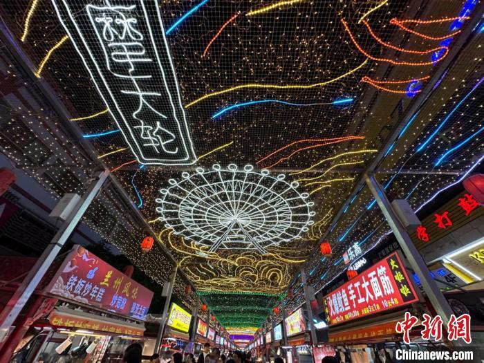 圖為明清街夜市燈光點(diǎn)亮具有武威文化元素的“摩天輪”彩燈?！〈魑牟?攝</p><p>