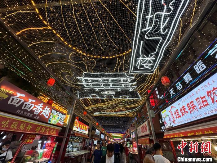 圖為明清街夜市燈光點(diǎn)亮具有武威文化元素的“涼州古城門”彩燈?！〈魑牟?攝</p><p>