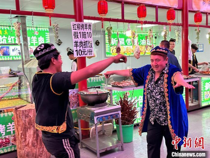 圖為餐飲經(jīng)營者在“西涼不夜城”跳起舞蹈引客?！〈魑牟?攝</p><p>