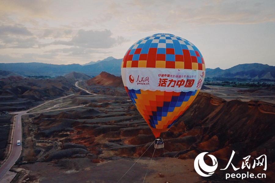 熱氣球在七彩丹霞上升起。人民網 李根攝