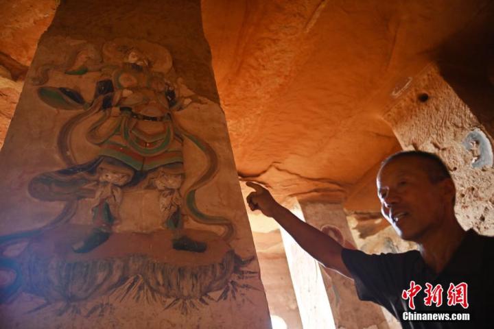 7月15日，甘肅省平?jīng)鍪袥艽h百里石窟長(zhǎng)廊羅漢洞石窟內(nèi)，該窟文保員郭建平介紹窟內(nèi)石刻彩繪壁畫(huà)。郭建平家中三代人曾自發(fā)保護(hù)羅漢洞石窟。羅漢洞石窟遺存40余個(gè)窟龕，以北魏至清代風(fēng)格為主。中新社記者 李亞龍 攝</p>
<p>