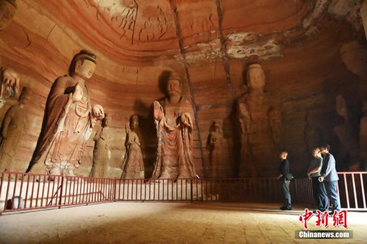 7月15日，游人參觀甘肅省平?jīng)鍪袥艽h百里石窟長(zhǎng)廊中的南石窟寺1號(hào)窟。百里石窟長(zhǎng)廊位于涇川縣境內(nèi)，由512個(gè)石窟、5眼窟中石井組成，現(xiàn)存王母宮石窟、鳳凰山石窟、南石窟寺、丈八寺石窟、羅漢洞石窟、太山寺石窟等規(guī)模較大的石窟群，還有數(shù)量眾多的小石窟群。南石窟寺開(kāi)鑿于北魏永平三年，其中1號(hào)窟屬于大型七佛窟，七佛高達(dá)6米。中新社記者 李亞龍 攝