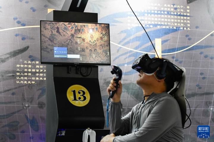 7月22日，游客借助VR設(shè)備沉浸式游覽莫高窟第285窟虛擬場景。新華社記者 郎兵兵 攝